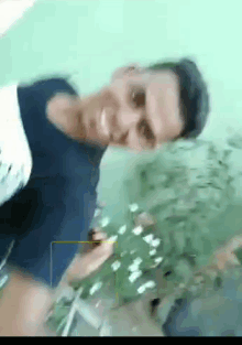 a blurry picture of a man holding a plant and smiling