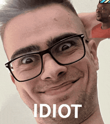 a man wearing glasses is making a funny face and the word idiot is on the bottom