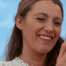 a close up of a woman 's face with pink lipstick and white teeth
