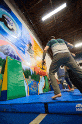 a man is jumping on a mat that says ava