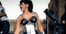 a woman in a futuristic costume is dancing in front of a crowd of people .