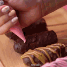 a close up of a person decorating a cake with the word mr.cakes visible