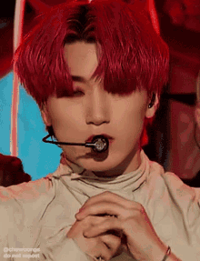 a close up of a person 's face with red hair and a microphone in their mouth .
