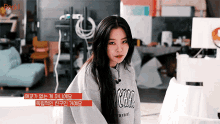 a girl wearing a grey sweatshirt that says pegang on it