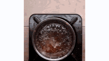 a pot of brown liquid is being cooked on a stove .