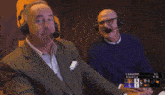 a man wearing headphones is making a funny face in front of a scoreboard that shows the score of 5 to 1