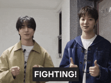 two young men are giving a thumbs up and one of them has a sign that says fighting