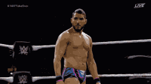 a shirtless wrestler is standing in a wrestling ring with the hashtag #nxttakeover on the bottom