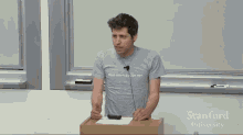 a man wearing a shirt that says hold something people want stands at a podium