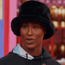 a woman wearing a black hat and a black hoodie
