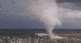 an aerial view of a tornado coming in towards a city