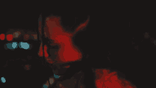 a close up of a woman 's face with red light behind her