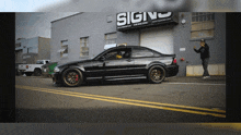 a car is parked in front of a building that says sign