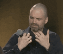 a man in a blue shirt is holding a microphone in his hands