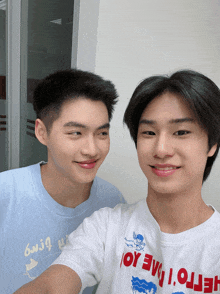 two young men are posing for a picture with one wearing a white shirt that says hello