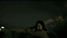 a person laying on the ground with a dog standing over them
