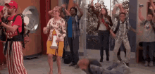 a group of people are dancing in a hallway while a woman is holding a megaphone .