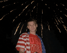 a man in an american flag shirt is holding a green can of soda