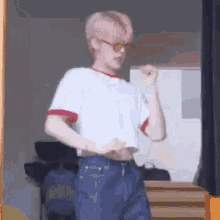 a man wearing a white crop top and blue jeans is standing in front of a mirror .