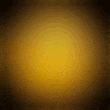 a yellow circle is glowing in the dark on a dark background .