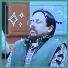 a man wearing glasses and a green vest with the words " you 're the " on his head