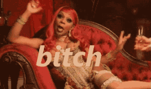 a woman with red hair is sitting on a red couch and the word bitch is visible