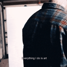 a man in a plaid shirt is standing in front of a white board and says " everything i do is art "