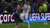 a soccer game is being played in front of a uefa super banner
