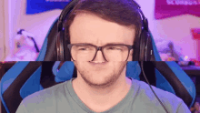 a man wearing glasses and headphones is making a face