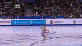 a woman is ice skating in front of a banner that says tech score