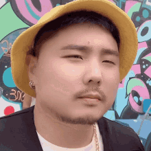 a man wearing a yellow hat and a white shirt has a beard