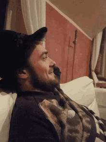 a man with a beard is laying on a couch with his eyes closed