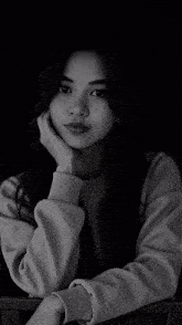 a woman 's face is partially obscured by a gray sweater