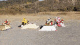 a group of robots are sitting on tables in a dirt field
