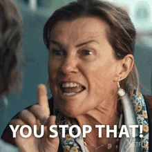 a woman is making a funny face with the words you stop that behind her