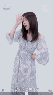a woman in a floral dress is making an ok sign with her hand