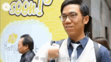 a man wearing glasses is holding a cup of latte