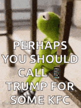 kermit the frog is sitting on a railing with a remote control in his hand .