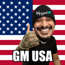 a man wearing a hat that says hazard is smiling in front of an american flag