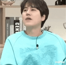 a young man wearing a blue sweater is making a face .