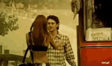 a man and a woman are hugging in front of a red bus that says special