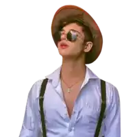 a young man wearing a hat and suspenders looks up at the sky