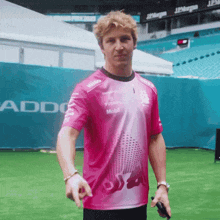 a man wearing a pink shirt that says addo