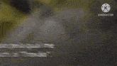 a blurred image of a person standing on top of a rock with a sword .