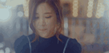 a close up of a woman 's face with her eyes closed and a blurry background .