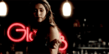 a woman is dancing in front of a gic 's sign