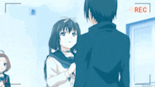 a boy and a girl are standing next to each other in front of a camera with a red rec sign .