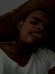 a man is sleeping in a dark room with his eyes closed