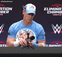a man wearing a shirt that says the last time is now holds a microphone