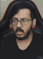 a man with glasses and a beard is making a face